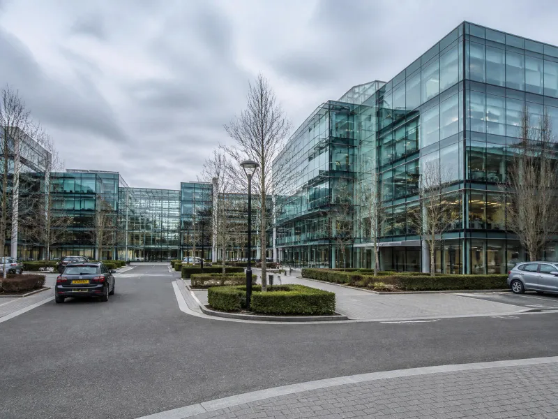 Private car travelling through a modern business district in Berkshire, representing private hire coverage across the county.
