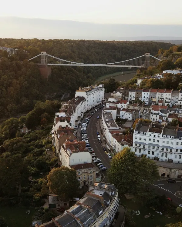 Vehicles travelling on a road beneath Clifton Suspension Bridge in Bristol